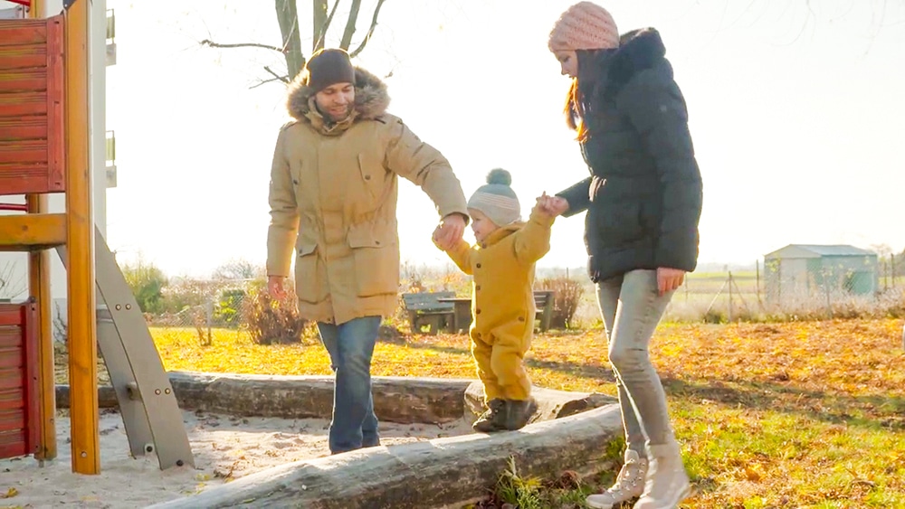 DEBATIN Familie auf dem Spielplatz mit Kind